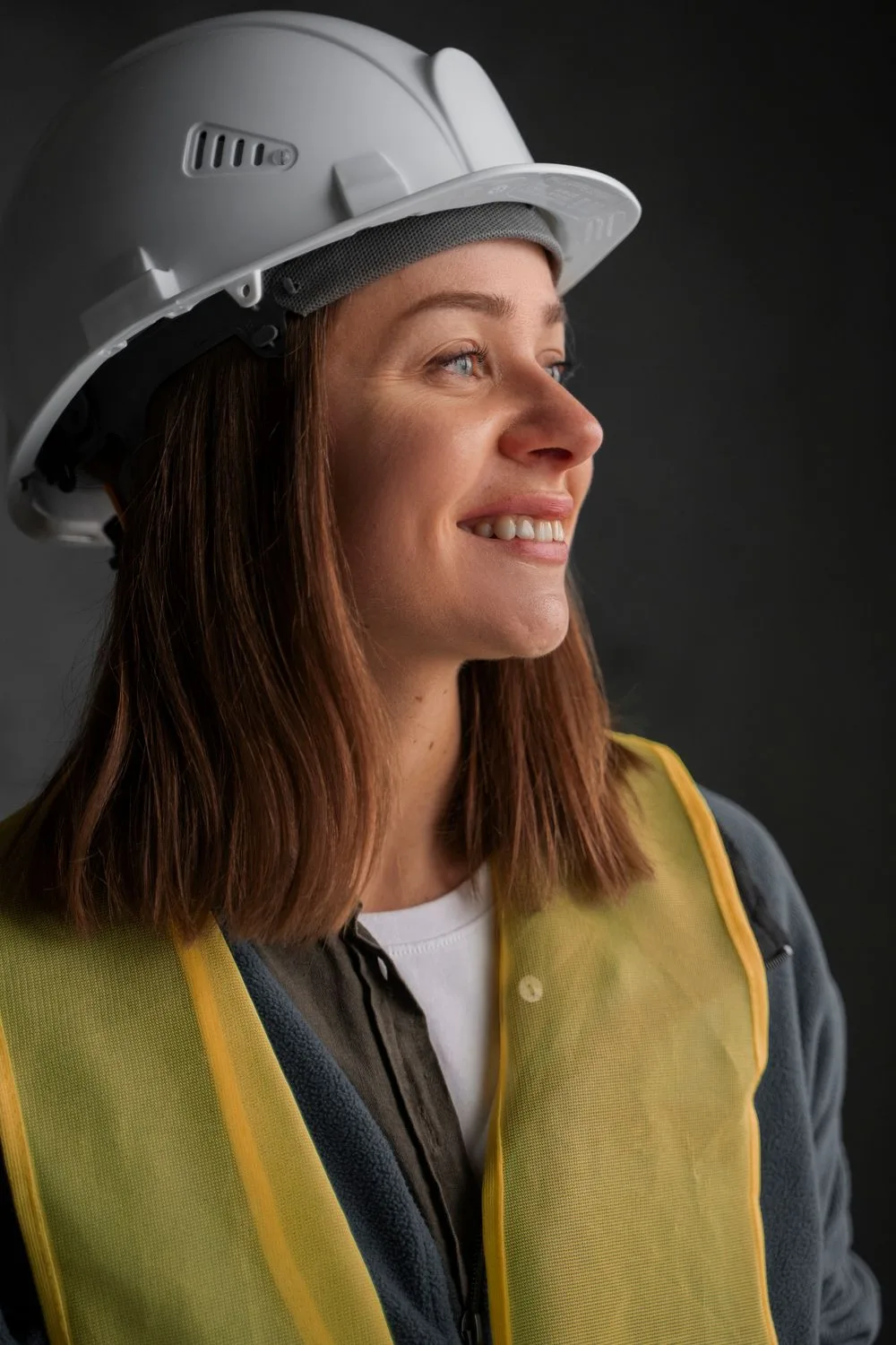 Profissional com capacete e colete de segurança do trabalho, com a marca Elevare - medicina e segurança do trabalho em Navegantes/SC